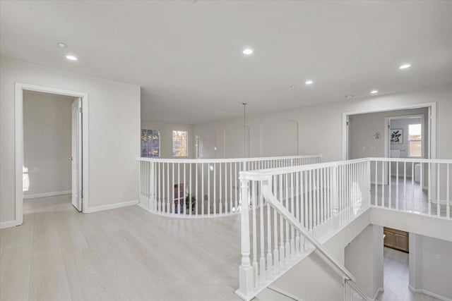 hallway with light hardwood / wood-style flooring and plenty of natural light