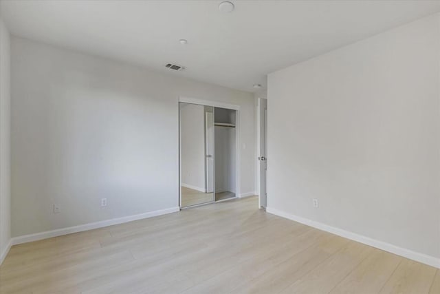 unfurnished bedroom with a closet and light hardwood / wood-style flooring