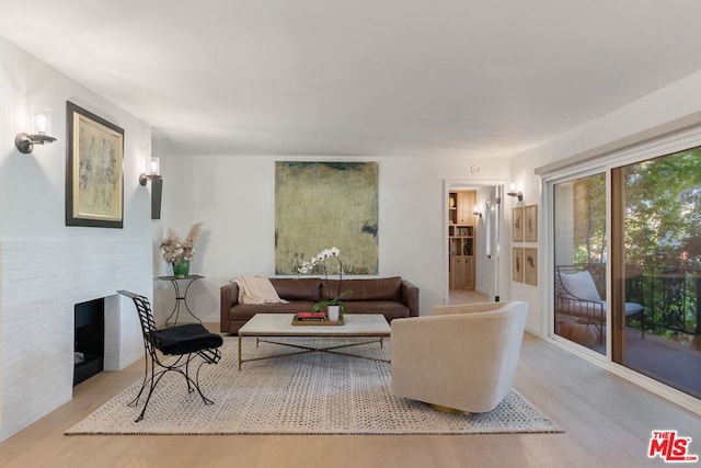 living room featuring light hardwood / wood-style floors and a brick fireplace