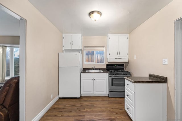 kitchen with stainless steel gas range oven, sink, dark hardwood / wood-style flooring, and white refrigerator