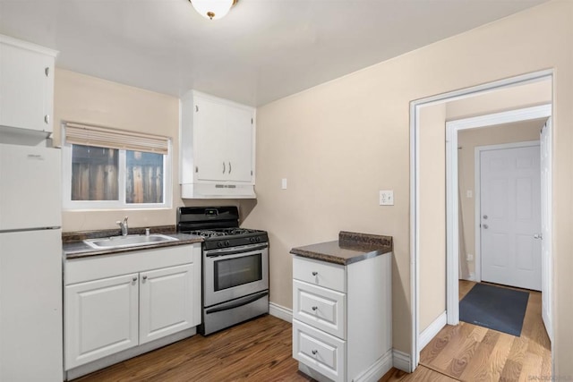 kitchen featuring sink, white refrigerator, light wood-type flooring, white cabinets, and stainless steel range with gas stovetop