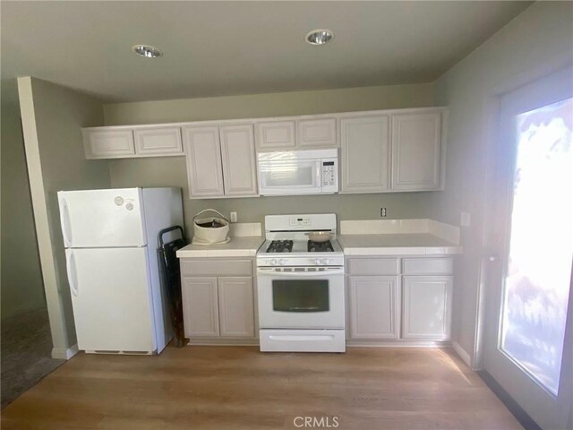 kitchen with white cabinetry, white appliances, and light hardwood / wood-style flooring