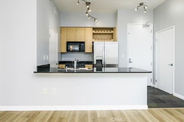 kitchen featuring stainless steel refrigerator with ice dispenser, sink, wood-type flooring, and kitchen peninsula