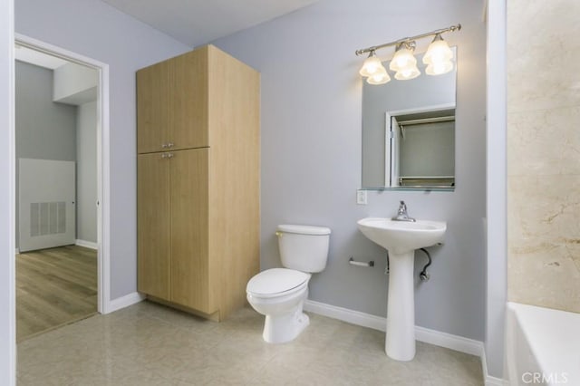 bathroom featuring toilet, tile patterned flooring, and a tub