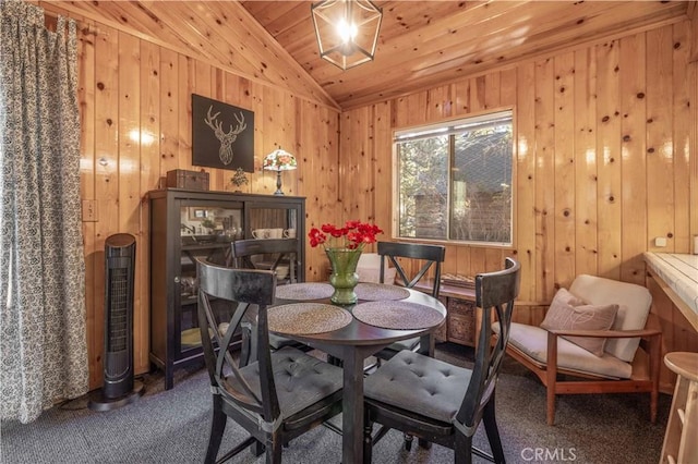 dining area featuring carpet floors, vaulted ceiling, wooden ceiling, and wood walls