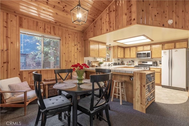 dining room with light colored carpet, high vaulted ceiling, wood walls, and wood ceiling