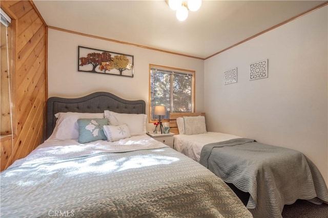 bedroom with ornamental molding and wooden walls