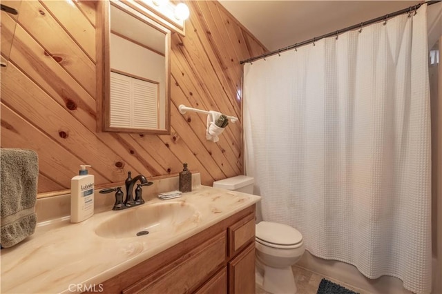 bathroom featuring tile patterned floors, wooden walls, vanity, and toilet