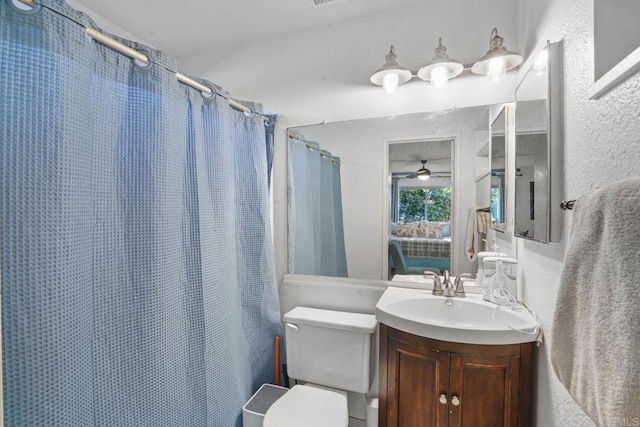 bathroom featuring a shower with curtain, vanity, toilet, and ceiling fan