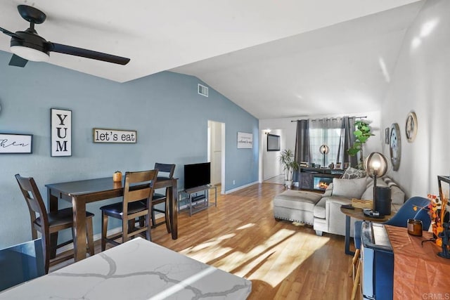 living room featuring ceiling fan, lofted ceiling, and hardwood / wood-style flooring