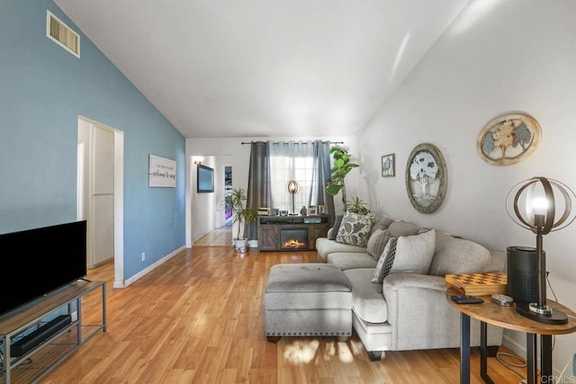 living room featuring light hardwood / wood-style flooring and vaulted ceiling