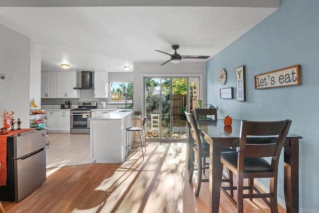 dining area with light wood-type flooring, ceiling fan, and sink