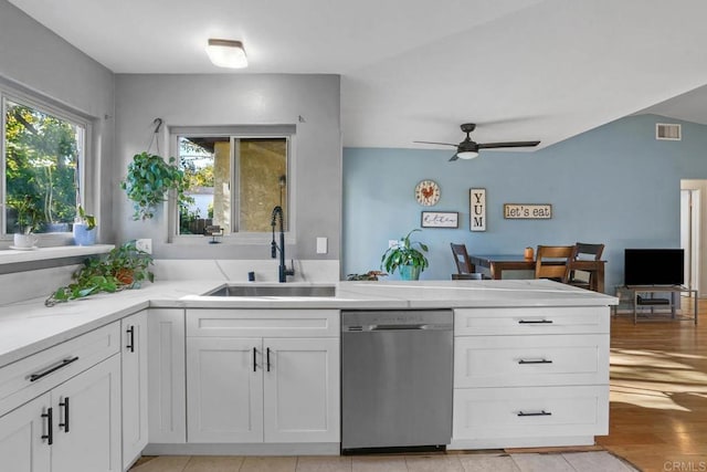 kitchen featuring ceiling fan, sink, light hardwood / wood-style flooring, stainless steel dishwasher, and white cabinets