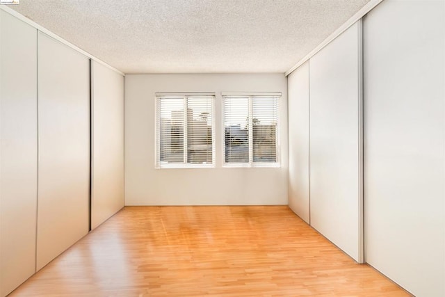 unfurnished bedroom featuring a textured ceiling and light hardwood / wood-style flooring