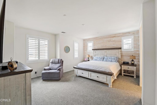 carpeted bedroom with wood walls