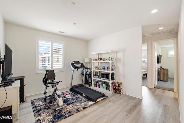 exercise room with light hardwood / wood-style floors