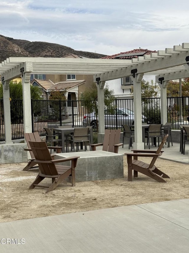 view of community with a mountain view, a patio area, and a pergola