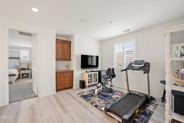 workout area with light hardwood / wood-style floors