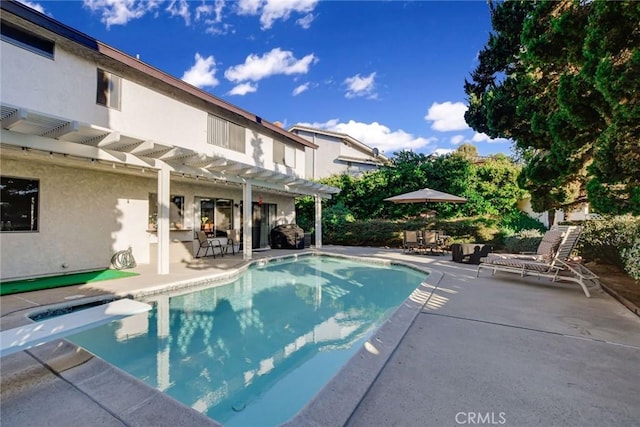 view of pool with a diving board and a patio area