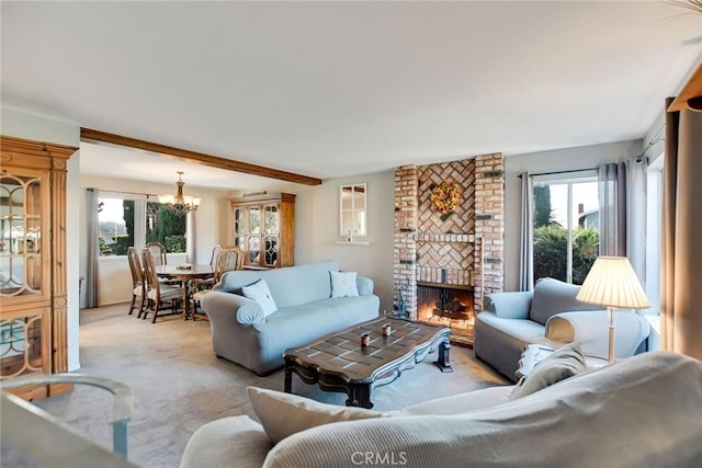 living room with a notable chandelier, light colored carpet, a fireplace, and a wealth of natural light