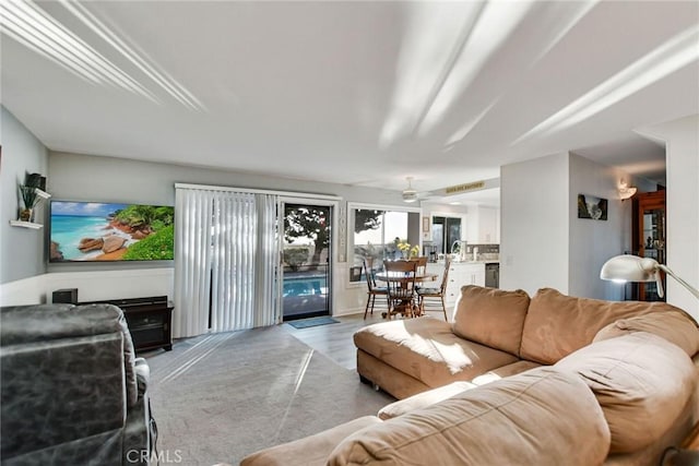 living room with light hardwood / wood-style flooring, ceiling fan, and sink