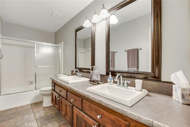 full bathroom featuring vanity, toilet, and enclosed tub / shower combo