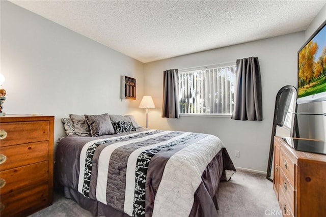 bedroom with light colored carpet and a textured ceiling