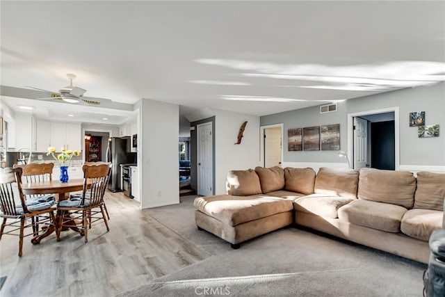 living room with light hardwood / wood-style floors and ceiling fan