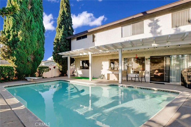 view of swimming pool with a diving board and a patio