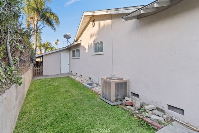 back of house with a lawn and central AC