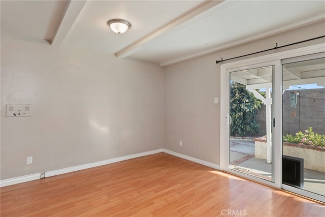 unfurnished room with beamed ceiling and wood-type flooring