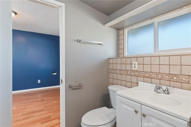 bathroom featuring vanity, toilet, a textured ceiling, tile walls, and wood-type flooring