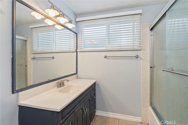 bathroom featuring tile patterned flooring, vanity, combined bath / shower with glass door, and a wealth of natural light