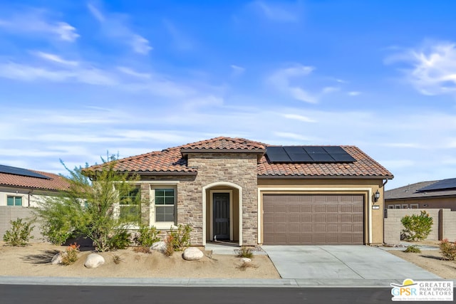 mediterranean / spanish-style home featuring solar panels and a garage