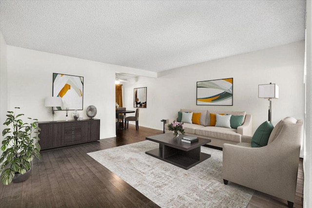 living room with a textured ceiling and dark hardwood / wood-style floors