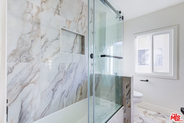 bathroom with combined bath / shower with glass door and toilet