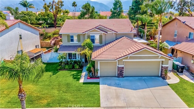 view of front of house with a mountain view, a garage, and a front lawn