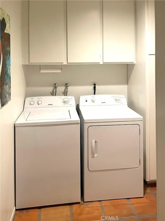 laundry room featuring washer and clothes dryer and cabinets