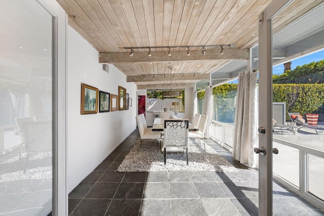 sunroom featuring beam ceiling, wood ceiling, and rail lighting