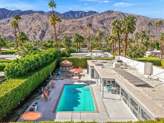 view of swimming pool with a mountain view and a patio