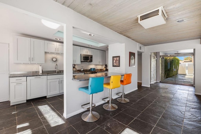 kitchen featuring sink, white cabinets, wood ceiling, and appliances with stainless steel finishes