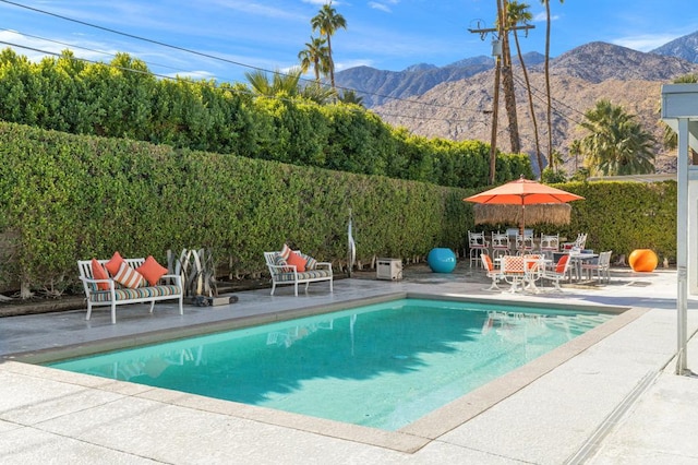 view of pool with a patio area and a mountain view