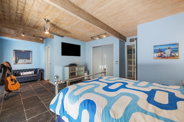 bedroom with beam ceiling, rail lighting, a closet, and wood ceiling