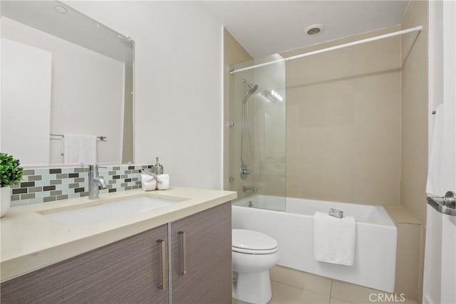 full bathroom with vanity, tile patterned floors, tiled shower / bath, toilet, and tasteful backsplash