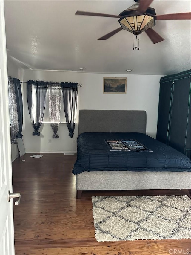 unfurnished bedroom featuring dark hardwood / wood-style floors and ceiling fan