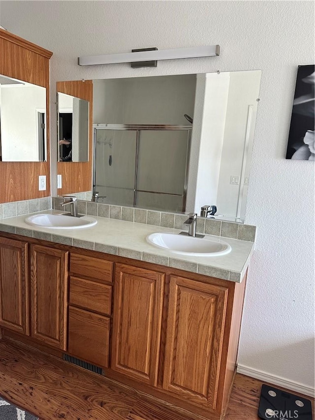 bathroom with vanity, wood-type flooring, and an enclosed shower