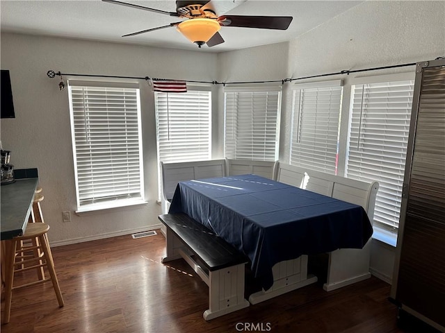 dining space featuring ceiling fan and dark hardwood / wood-style flooring