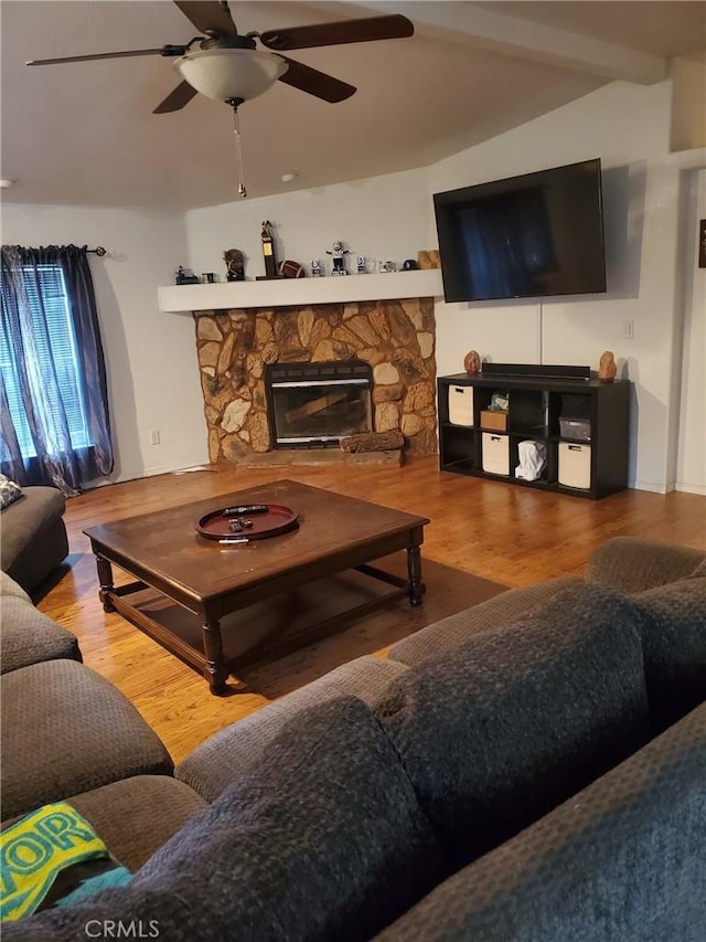 living room with a stone fireplace, ceiling fan, and wood-type flooring