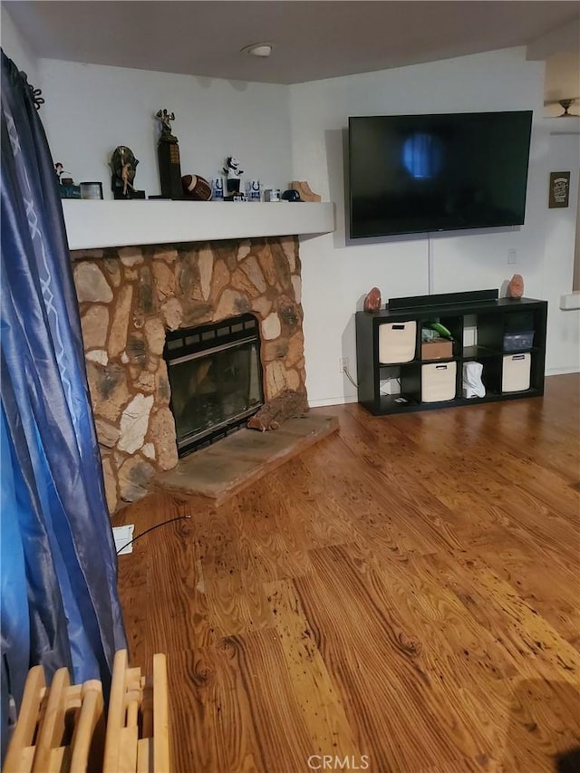 living room featuring hardwood / wood-style floors, radiator heating unit, and a fireplace