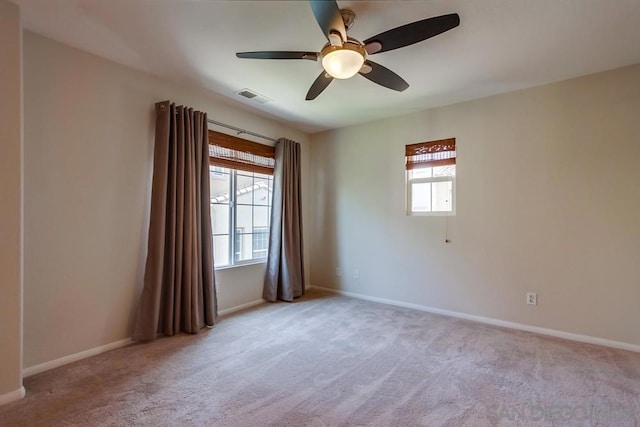 unfurnished room with light colored carpet and ceiling fan